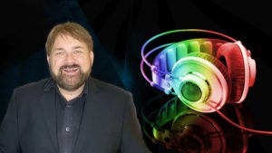 Foto mit DJ Kiel lachend daneben neon farbige Kopfhörer vom DJ